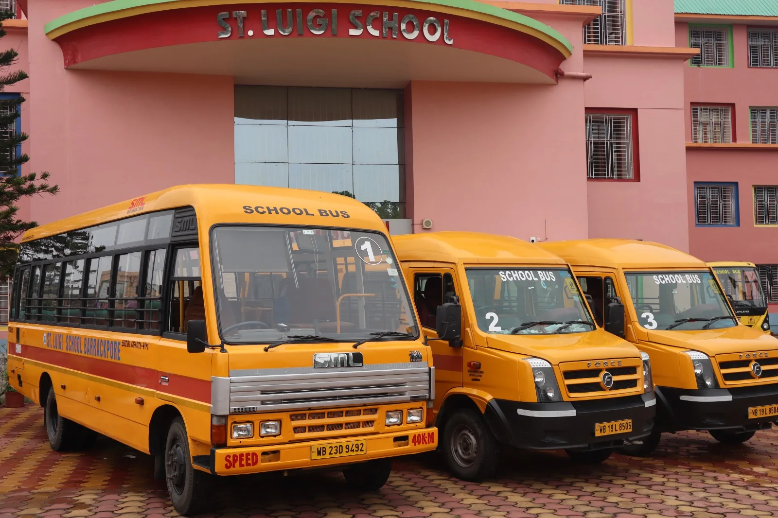 The St. Luigi School bus fleet parked in front of the school building